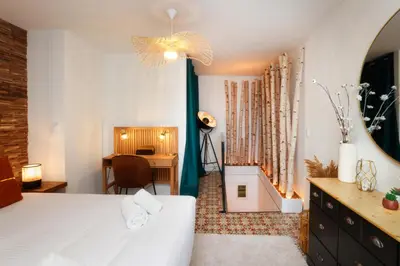 a bedroom with a bed and a desk and a chair at Le Cocon de la Cité - Parking au Pied de La Cité in Carcassonne