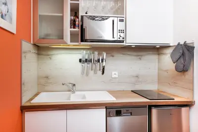 a kitchen with a sink and a microwave at Le Cocon de la Cité - Parking au Pied de La Cité in Carcassonne