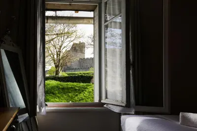 a window in a bedroom with a view of a building at Le Cocon de la Cité - Parking au Pied de La Cité in Carcassonne