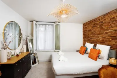 a bedroom with a white bed and a brick wall at Le Cocon de la Cité - Parking au Pied de La Cité in Carcassonne