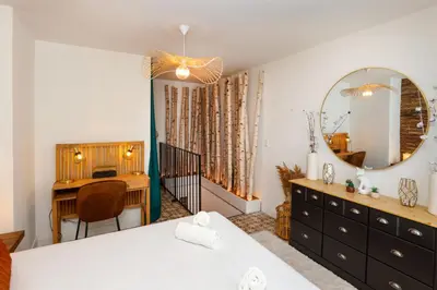 a bedroom with a bed and a desk and a mirror at Le Cocon de la Cité - Parking au Pied de La Cité in Carcassonne