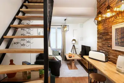 a loft apartment with a staircase and a desk at Le Cocon de la Cité - Parking au Pied de La Cité in Carcassonne