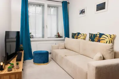 a living room with a couch and a tv at Le Pied à Terre de la Cité - Parking au Pied de la Cité in Carcassonne