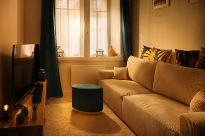 a living room with a couch and a window at Le Pied à Terre de la Cité - Parking au Pied de la Cité in Carcassonne