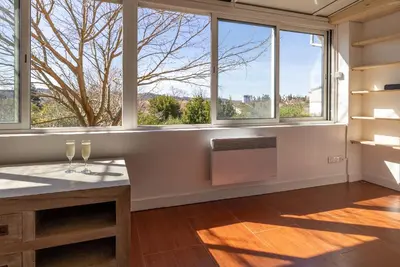 a room with windows and a table with wine glasses on it at Pamiers gare - 2 Appartements à louer ou Chambre parentale indépendante in Pamiers