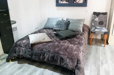 a bed with pillows on it in a room at Pamiers gare - 2 Appartements à louer ou Chambre parentale indépendante in Pamiers