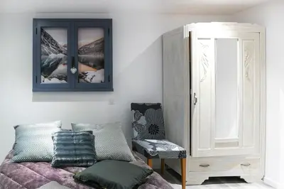 a bedroom with a bed and a cabinet and a chair at Pamiers gare - 2 Appartements à louer ou Chambre parentale indépendante in Pamiers