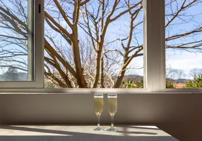 two champagne glasses sitting in front of a window at Pamiers gare - 2 Appartements à louer ou Chambre parentale indépendante in Pamiers