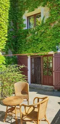 a patio with a table and a chair and a table and a table at La maison d' Anne , nature et convivialité ... in Albas