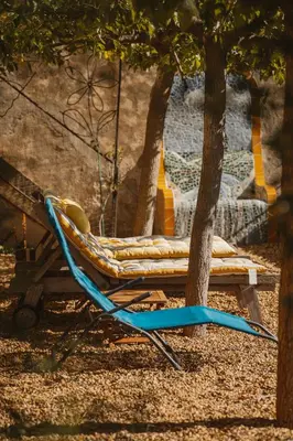 a hammock sitting under a tree next to a tree at Le Relais de Tamaroque in Portel-des-Corbières