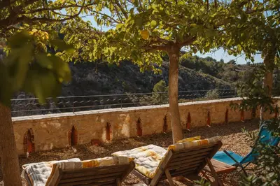 a table and two chairs sitting under a tree at Le Relais de Tamaroque in Portel-des-Corbières