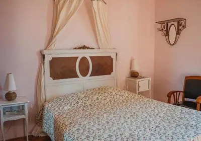a bedroom with a large bed with a canopy at Le Relais de Tamaroque in Portel-des-Corbières
