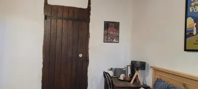 a room with a wooden door and a desk with a computer at LA CHAMBRE DU CANTOU in Lautrec