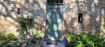 a door on the side of a stone building at LA CHAMBRE DU CANTOU in Lautrec
