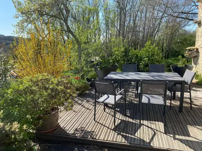 a table and chairs on a deck with plants at LA CHAMBRE DU CANTOU in Lautrec
