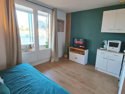 a bedroom with a bed and a tv and a window at Splendide appartement GOLDEN HOUSE vue LAC et montagne in Port-la-Nouvelle