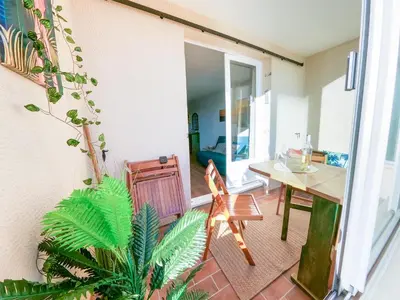 a room with a table and chairs and a dining room at Splendide appartement GOLDEN HOUSE vue LAC et montagne in Port-la-Nouvelle