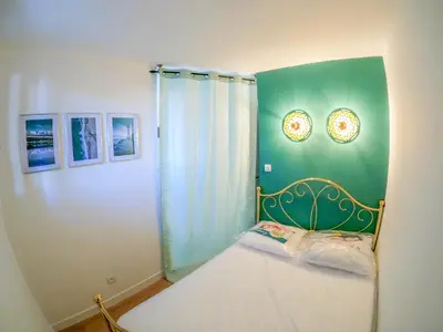 a bedroom with a bed with a green wall at Splendide appartement GOLDEN HOUSE vue LAC et montagne in Port-la-Nouvelle