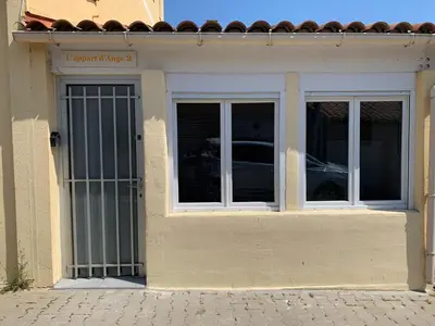 a building with a door and two windows at L appart d Ange 2 idealement situe 47m2 entre le port et le village in Gruissan