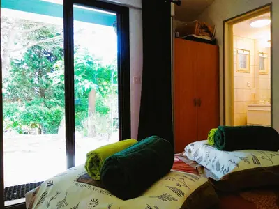 a bedroom with two beds with green pillows and a window at Chambre Indépendante Piscine, Parc, Cuisine... in Brézilhac