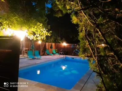 a swimming pool at night with chairs around it at Chambre Indépendante Piscine, Parc, Cuisine... in Brézilhac