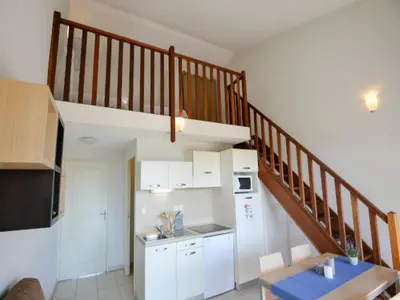 a kitchen with white cabinets and a staircase at Apartment in Azille near Lac de Jouarres in Azille