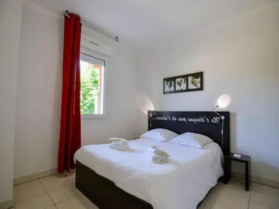 a bedroom with a large bed with a red curtain at Apartment in Azille near Lac de Jouarres in Azille
