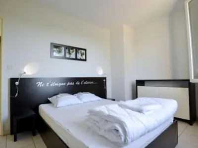a bedroom with a black and white bed with white towels at Apartment in Azille near Lac de Jouarres in Azille