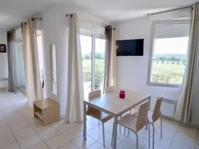a dining room with a table and chairs and a window at Apartment in Azille near Lac de Jouarres in Azille