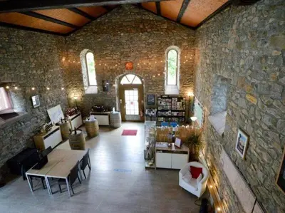 a large room with a stone wall with a table in it at Apartment in Azille near Lac de Jouarres in Azille