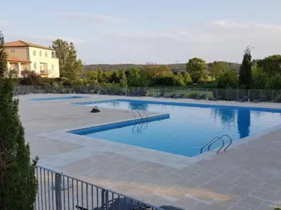 a large pool with blue water in a yard at Apartment in Azille near Lac de Jouarres in Azille