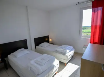 two beds in a room with a window at Apartment in Azille near Lac de Jouarres in Azille