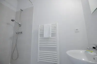 a white bathroom with a shower and a sink at Residence du Château de Jouarres, Azille - Studio 2 pers with balcony in Azille