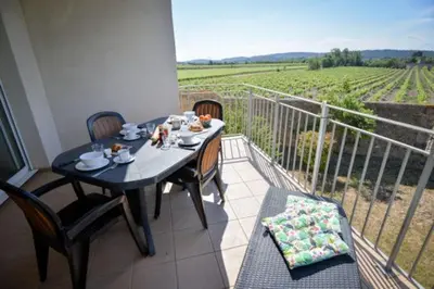 a table and chairs on a balcony with a view at Residence du Château de Jouarres, Azille - Studio 2 pers with balcony in Azille