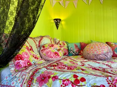 a bed with pillows on it in a green room at Gîte Les logis du Pech in Narbonne