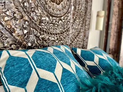 a couch with blue and white pillows on it at Gîte Les logis du Pech in Narbonne