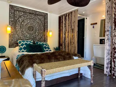 a bedroom with a bed with a large headboard at Gîte Les logis du Pech in Narbonne