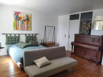 a bedroom with a bed and a couch and a piano at Aur Blan - Les Pipistrelles in Le Somail