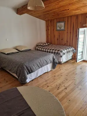 two beds in a room with wooden floors at Le lorrain in Campagne-sur-Aude