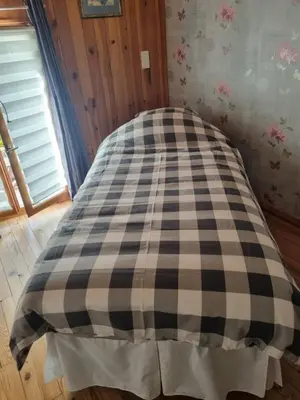 a bed in a room with a checkered blanket at Le lorrain in Campagne-sur-Aude