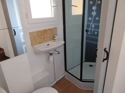 a bathroom with a sink and a glass shower at centre historique et proche mer in Sigean