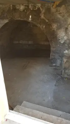 a dark room with a stone wall and a tunnel at centre historique et proche mer in Sigean