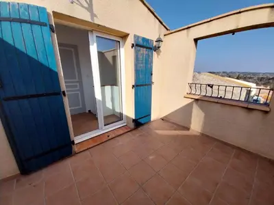 a balcony with blue doors and a view of the ocean at centre historique et proche mer in Sigean