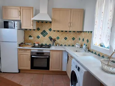 a kitchen with a white refrigerator and a sink at centre historique et proche mer in Sigean