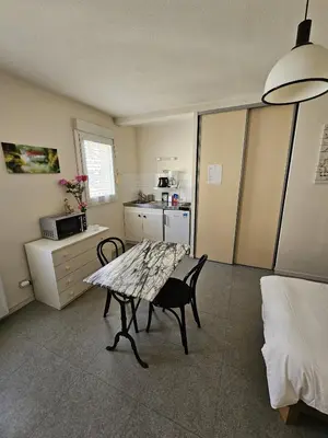 a kitchen with a table and chairs in a room at Résidence Anclo in Rennes-les-Bains