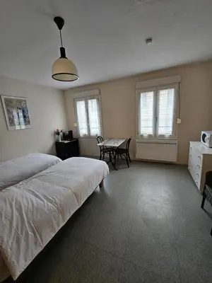 a bedroom with two beds and a table and chairs at Résidence Anclo in Rennes-les-Bains