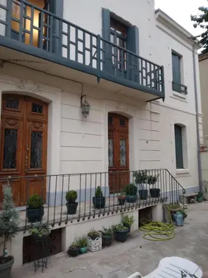 a white house with potted plants in front of it at Beausejour in Lézignan-Corbières