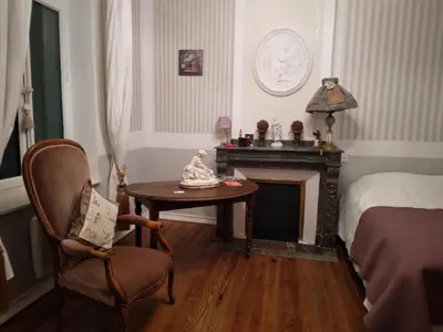 a bedroom with a chair and a table and a bed at Beausejour in Lézignan-Corbières