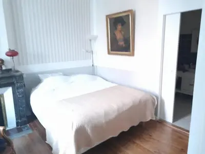a bedroom with a white bed with a picture on the wall at Beausejour in Lézignan-Corbières