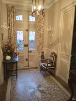 a hallway with a chair and a door with windows at Beausejour in Lézignan-Corbières